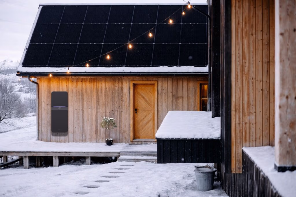 Solceller på vintern och Polarium hembatteri på träfasad