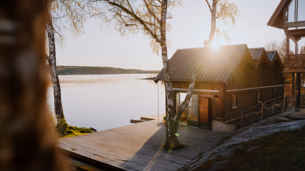 Polarium hembatteri i röd färg på träfasad vid sjön