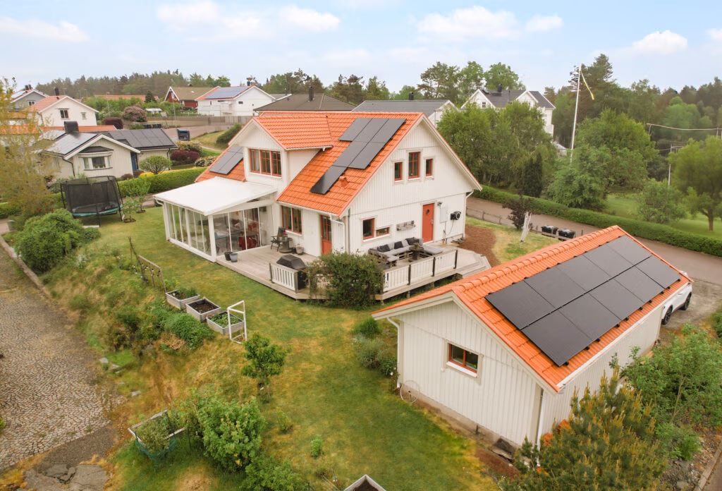 Solceller med hembatteri smart energilagring på rött tegeltak