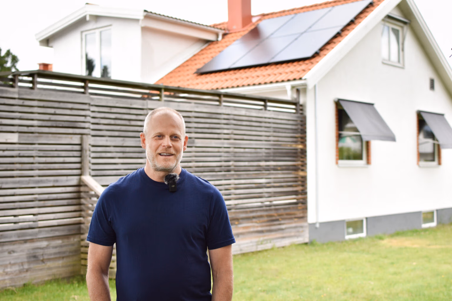Nöjd kund poserar framför sin solcellsanläggning anpassad för villa.